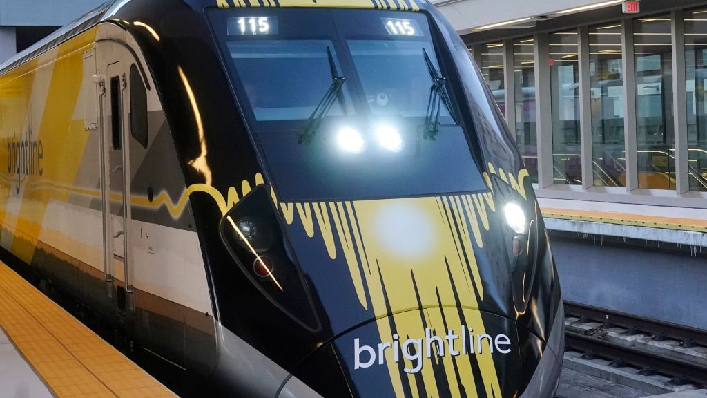 A Brightline train stopped at a train station. 
