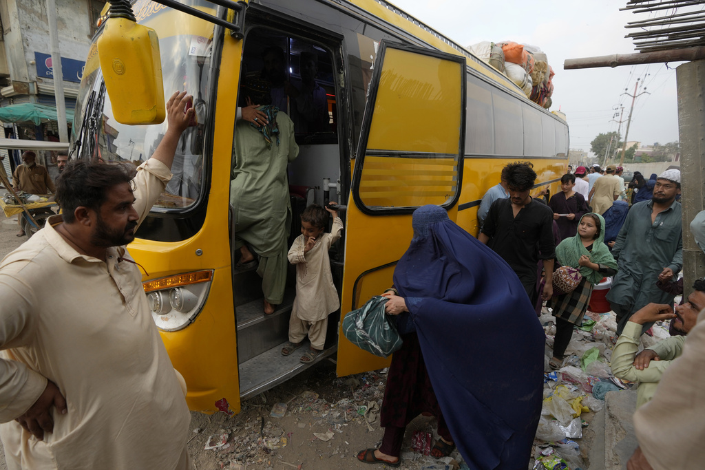 Afghan families board into a bus to depart for their homeland, in Karachi, Pakistan, Friday, Oct. 6, 2023. Pakistan's government announced a major crackdown Tuesday on migrants in the country illegally, saying it would expel them starting next month and raising alarm among foreigners without documentation who include an estimated 1.7 million Afghans. (AP Photo/Fareed Khan)