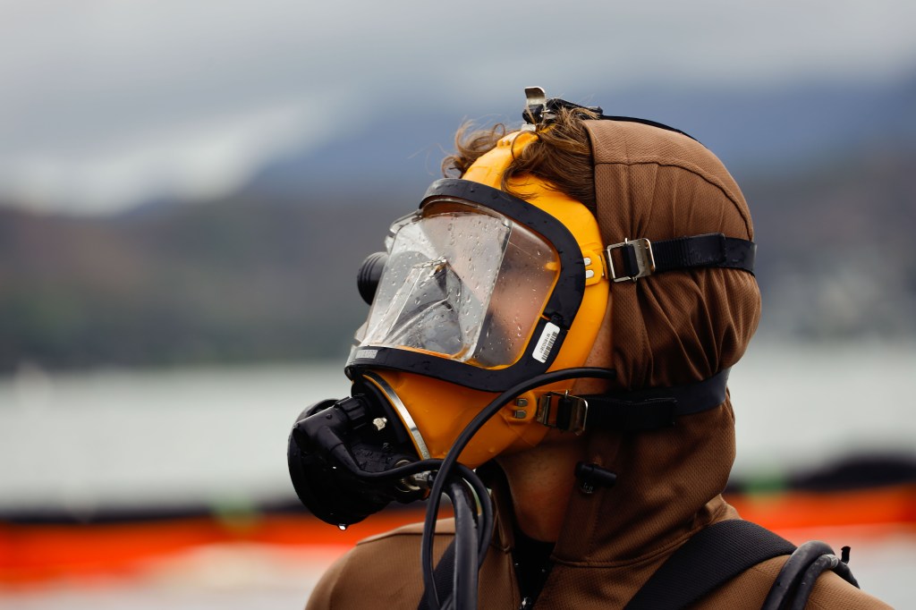 A U.S. Sailor with Company 1-3, Mobile Diving and Salvage Unit 1, prepares to dive and detach a fuel hose after completing defueling operations on a downed U.S. Navy P-8A Poseidon in waters just off the runway at Marine Corps Air Station Kaneohe Bay, Marine Corps Base Hawaii, Nov. 26, 2023. The successful defueling of the downed P-8A was critical to the execution of the aircraft salvage plan. (U.S. Marine Corps photo by Sgt. Brandon Aultman)
