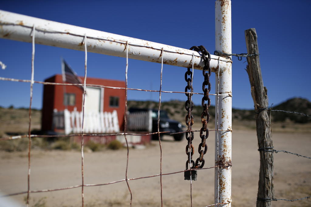FILE - A rusted chain hangs on the fence at the entrance to the Bonanza Creek Ranch film set in Santa Fe, N.M., Wednesday, Oct. 27, 2021. A New Mexico judge has approved a $1.15 million settlement Monday, May 8, 2023, between a medic who worked on the “Rust” film set and one of several defendants she accused of negligence in the fatal 2021 shooting of a cinematographer by Alec Baldwin during a rehearsal. (AP Photo/Andres Leighton,File)