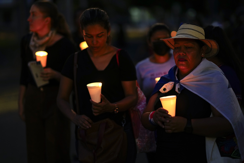 Women hold candles during a vigil at a protest against a recently approved mining contract between the government and Canadian mining company First Quantum in Panama City, Wednesday, Nov 8, 2023. Two people died on Tuesday while participating in a third week of protests against a the controversial government mining contract in Panama, officials confirmed. (AP Photo/Arnulfo Franco)