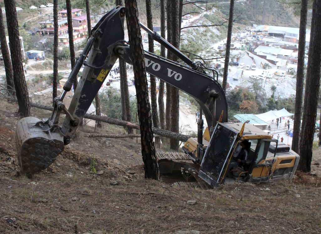 An earth-mover makes a vertical drill on the top of a mountain where a tunnel that collapsed in Uttarakhand state, India, Saturday, Nov. 18, 2023. Forty workers were trapped in the collapsed road tunnel in northern India for a seventh day Saturday as rescuers waited for a new machine to drill through the rubble so they could crawl to their freedom. (AP Photo)