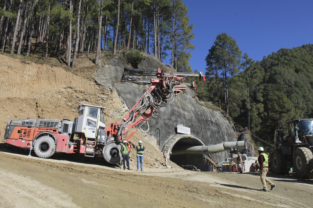 A heavy machinery works at the the entrance to the site of an under-construction road tunnel that had collapsed trapping 40 workers in Silkyara in the northern Uttarakhand state, India, Monday, Nov. 20, 2023. (AP Photo)