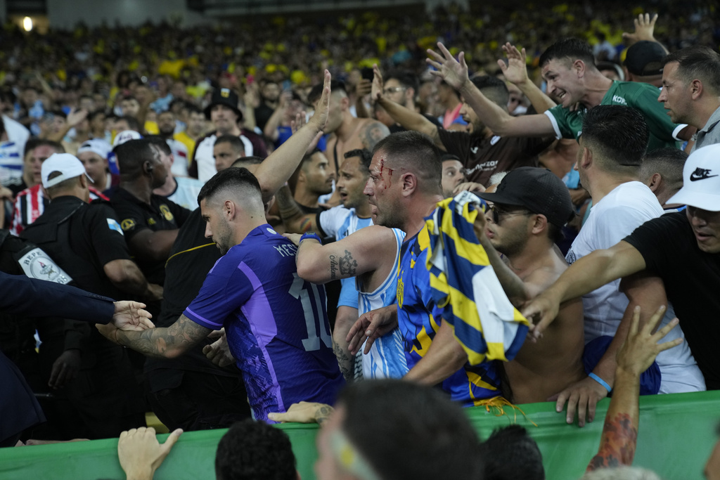Brazilian and Argentinians fans fight at the stands prior to a qualifying soccer match for the FIFA World Cup 2026 between Brazil and Argentina at Maracana stadium in Rio de Janeiro, Brazil, Tuesday, Nov. 21, 2023. (AP Photo/Silvia Izquierdo)