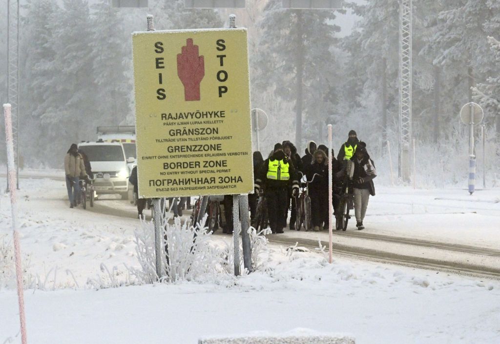 Finnish border guards escort migrants with bicycles at the international border crossing with Russia at Salla, Finnish Lapland on November 21, 2023. Last week, Helsinki shut four of its crossings, claiming Moscow was seeking to destabilise Finland by letting undocumented migrants cross into the Nordic country. Russia denied on on November 20 accusations that it was sending migrants to the Finnish border and warned earlier that Finland could close all its border crossings. (Photo by Jussi Nukari / Lehtikuva / AFP) / Finland OUT (Photo by JUSSI NUKARI/Lehtikuva/AFP via Getty Images)