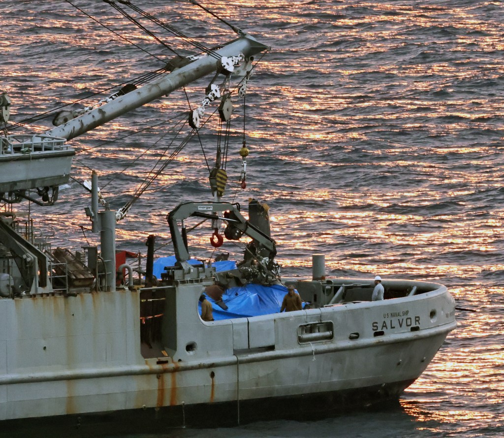 An object believed to be part of the US V-22 Osprey, which crashed on Nov. 29, is lifted by an US salvage vessel in Yakushima Town, Kagoshima Prefecture on Dec. 27, 2023.   Of the eight crew members who were on board the Osprey, the bodies of seven have been recovered.　( The Yomiuri Shimbun )