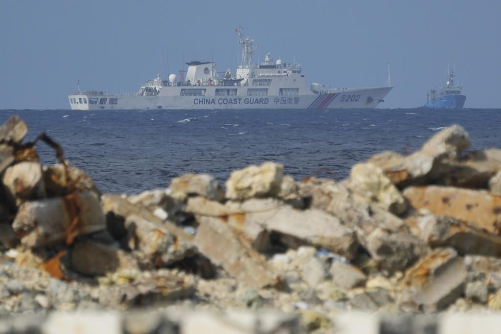 A Chinese coast guard vessel goes near the Philippine-occupied Thitu island, locally called Pag-asa island, on Friday, Dec. 1, 2023, at the disputed South China Sea. The Philippine coast guard inaugurated a new monitoring base Friday on a remote island occupied by Filipino forces in the disputed South China Sea as Manila ramps up efforts to counter China's increasingly aggressive actions in the strategic waterway. (AP Photo/Aaron Favila)