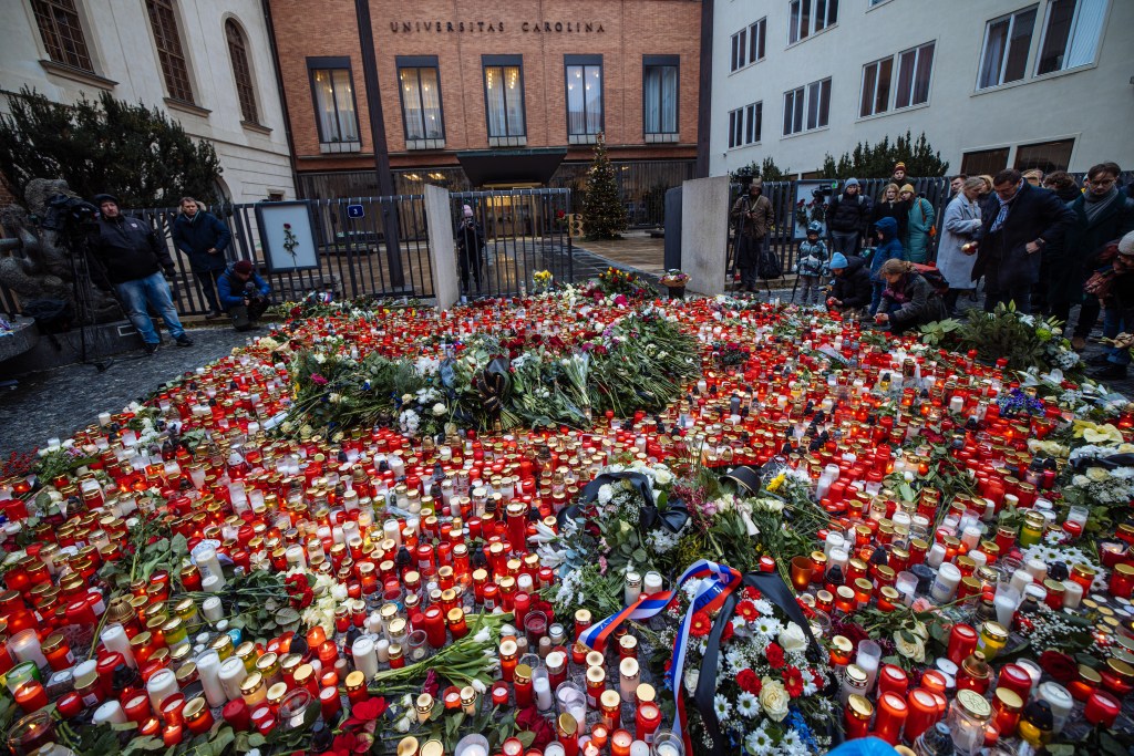 PRAGUE, CZECH REPUBLIC - DECEMBER 22: People lay flowers and light candles as they pay their respects in front of the Charles University's main building following a mass shooting in central Prague, Czech Republic on December 22, 2023. In a press conference held on Friday to give further details on the attack, Petr Matejcek, the Prague police chief, said that 14 people were killed and 25 others wounded in the attack by a gunman as he opened fire inside the corridors and classrooms of the Faculty of Arts building at Charles University. (Photo by Stringer/Anadolu via Getty Images)