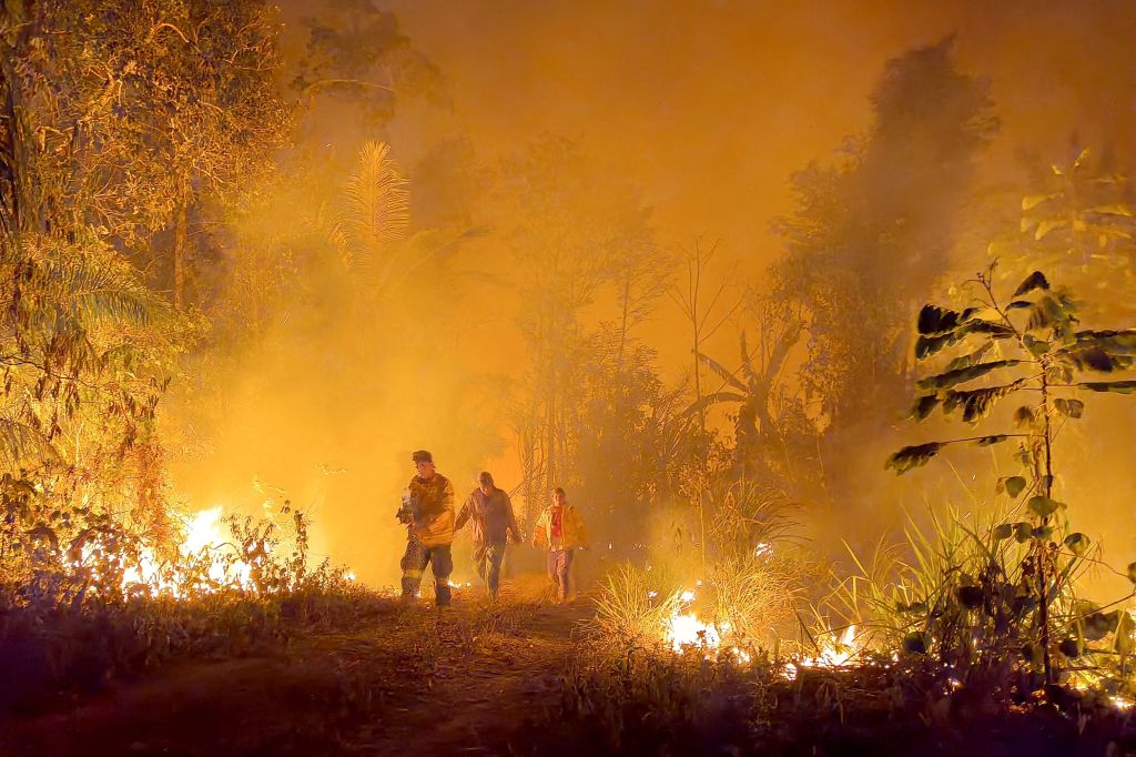 TOPSHOT - Volunteers and firefighters combat the fires that went out of control during the burning of forests and pastures for agricultural purposes in Rurrunabaque, Beni Department, Bolivia, on November 16, 2023. (Photo by Cristian CASTRO / AFP) (Photo by CRISTIAN CASTRO/AFP via Getty Images)