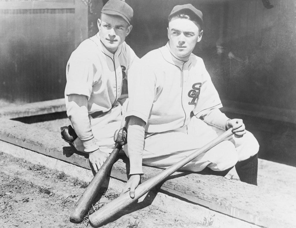 San Francisco Seals players Jimmy O'Connell (L) and Willie Kamm sit together on the edge of the dugout.